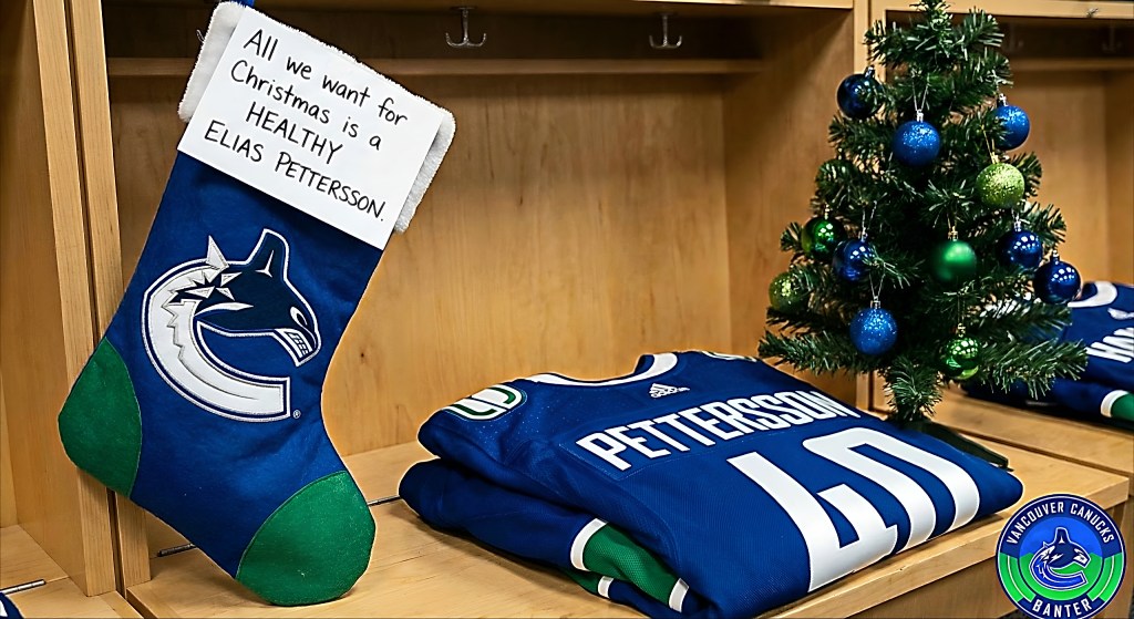A Christmas stocking with a message wishing for a healthy Elias Pettersson, placed next to a Canucks jersey and a small Christmas tree decorated with ornaments.