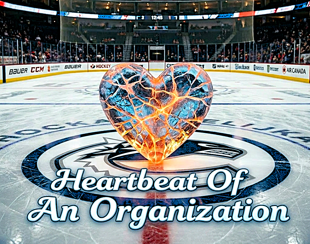 A stylized, ice sculpture in the shape of a heart, glowing with orange light, placed on a hockey rink. The background shows a hockey arena filled with spectators.
